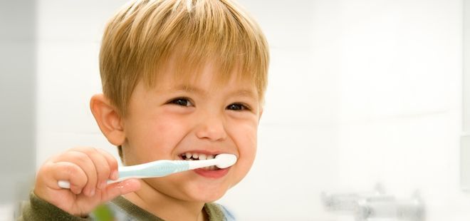 Niño lavándose los dientes.